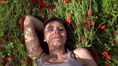 Kız gelincikler arasında geri doğru eğilir.