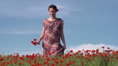 kısa saçlı kadın modeli, yavaş yavaş çiçekler arasında yürüyor