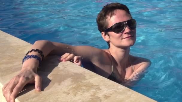 Menina segura-se ao lado da piscina — Vídeo de Stock