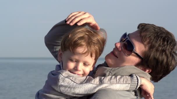 Kleiner Sohn umarmt ihre Mutter und blinzelt in die Sonne — Stockvideo