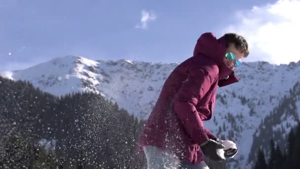 Semester i bergen. ung kvinna kasta snöbollar — Stockvideo