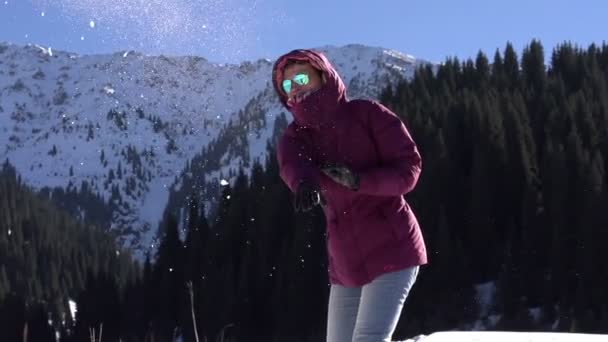 Juego de bolas de nieve. Mujer joven lanzando bolas de nieve — Vídeo de stock