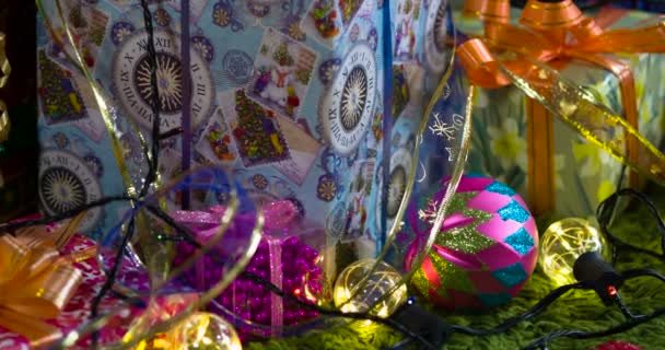 圣诞假期气氛 相机缓慢地沿着各种礼品盒移动 礼品盒上装饰着闪闪发光的弓 圣诞树装饰和闪闪发光的花环 — 图库视频影像
