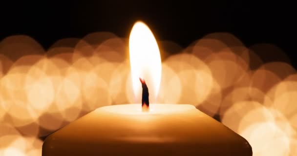 背景多变的烛台 一支大蜡烛在一组模糊不清的灯光的映衬下关上了 — 图库视频影像