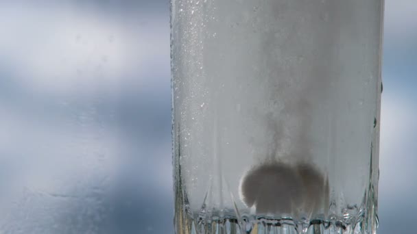 発酵錠は泡を作成します 空に向かって立つガラスの中に落ち込む石灰石の錠剤 120Fpsの速度で撮影 — ストック動画