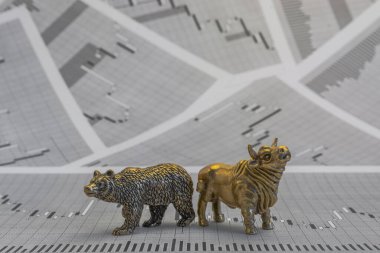 Hisse senedi fiyatlarının arka planında metalik sarı boğa ve ayı figürleri var. Ticaret sembollerini değiş tokuş edin. Para ve menkul kıymetler piyasasında alıcılar ve satıcılar arasındaki mücadele kavramı