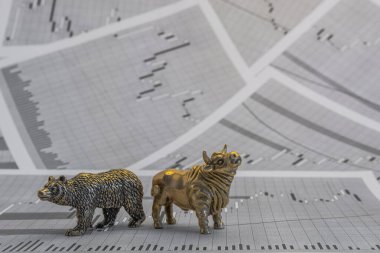 Hisse senedi fiyatlarının arka planında metalik sarı boğa ve ayı figürleri var. Ticaret sembollerini değiş tokuş edin. Para ve menkul kıymetler piyasasında alıcılar ve satıcılar arasındaki mücadele kavramı