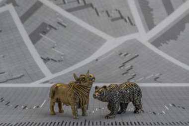 Hisse senedi fiyatlarının arka planında metalik sarı boğa ve ayı figürleri var. Ticaret sembollerini değiş tokuş edin. Para ve menkul kıymetler piyasasında alıcılar ve satıcılar arasındaki mücadele kavramı