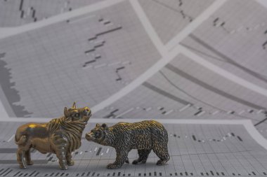Hisse senedi fiyatlarının arka planında metalik sarı boğa ve ayı figürleri var. Ticaret sembollerini değiş tokuş edin. Para ve menkul kıymetler piyasasında alıcılar ve satıcılar arasındaki mücadele kavramı