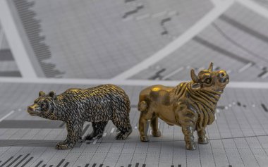 Hisse senedi fiyatlarının arka planında metalik sarı boğa ve ayı figürleri var. Ticaret sembollerini değiş tokuş edin. Para ve menkul kıymetler piyasasında alıcılar ve satıcılar arasındaki mücadele kavramı
