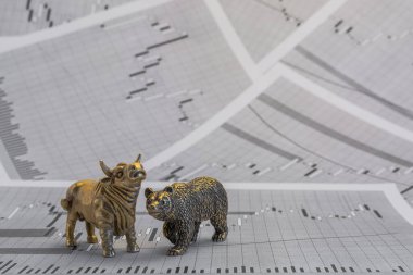 Hisse senedi fiyatlarının arka planında metalik sarı boğa ve ayı figürleri var. Ticaret sembollerini değiş tokuş edin. Para ve menkul kıymetler piyasasında alıcılar ve satıcılar arasındaki mücadele kavramı