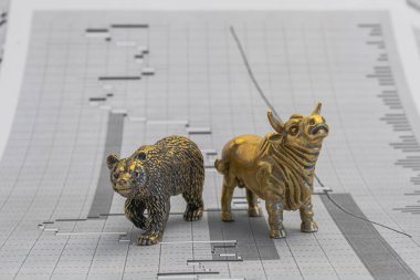 Hisse senedi fiyatlarının arka planında metalik sarı boğa ve ayı figürleri var. Ticaret sembollerini değiş tokuş edin. Para ve menkul kıymetler piyasasında alıcılar ve satıcılar arasındaki mücadele kavramı
