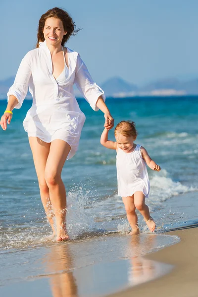 Mother and daughter walking on the beach — Stock Photo, Image