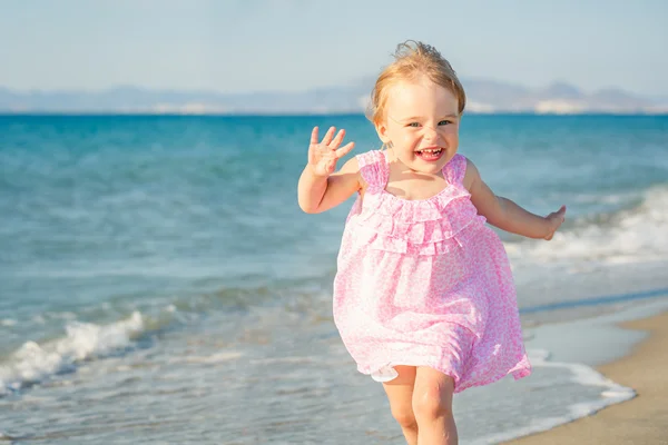 Liten flicka som springer på stranden — Stockfoto