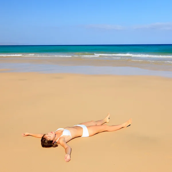 Νεαρή γυναίκα χαλαρώνοντας στην παραλία ωκεανό — Φωτογραφία Αρχείου