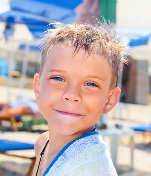 Smiley sju år gammal pojke på stranden — Stockfoto