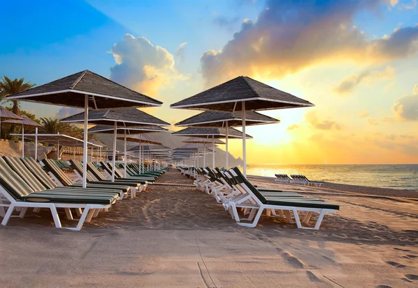 Cadeiras de praia e umrellas ao amanhecer — Fotografia de Stock