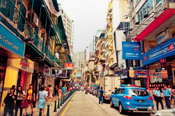 Narrow crowded street with many shops and restaurants in the centre of Macau. Stock Picture