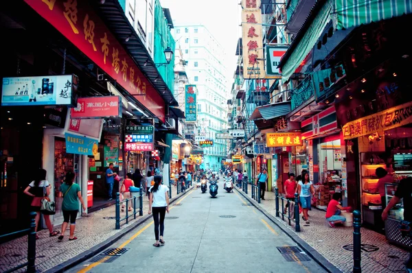 Narrow crowded street with many shops and restaurants in the centre of Macau. Stock Photo