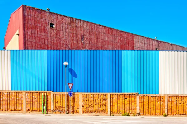 Промисловий склад і кольоровий паркан — стокове фото