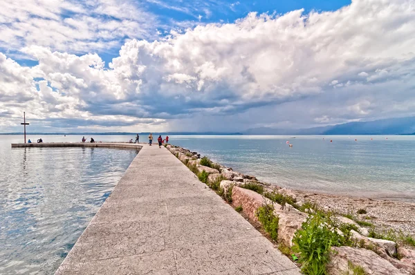 Molo s dramatickou oblohu nad jezero garda - Itálie — Stock fotografie