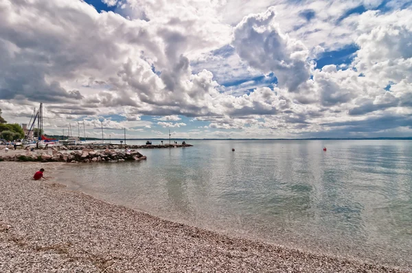 Muelle con cielo dramático sobre el lago de Garda - Italia — Foto de Stock