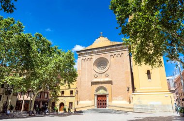Barcelona, İspanya - 7 Temmuz 2017: Placa de la Concordia ve Eglesia de Santa Maria del Remei 'nin Barcelona, İspanya' daki banklarda yerel halk ile gündüz görüşü. Les Corts, 20. yüzyılın başlarına kadar Barselona 'dan bağımsız bir kasabaydı.