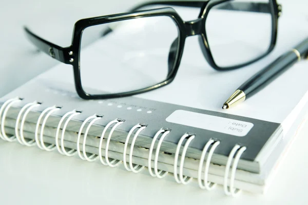 Gafas y bolígrafo en diario —  Fotos de Stock