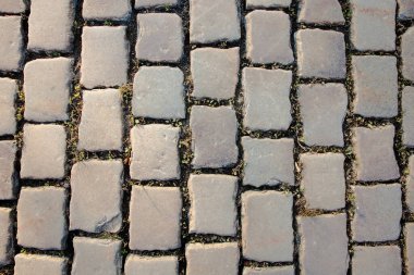 Kayalık taşlar, yol gri kare karolarla döşenmiş. Taş dokusu, grunge arkaplanı.