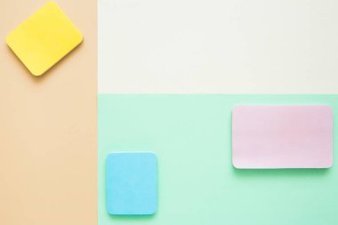 Kağıt üzerinde parlak renkli boş çıkartma blokları, üst görünüm. Pastel renklerde geometrik düzen. Şablon, boşluğu kopyala.
