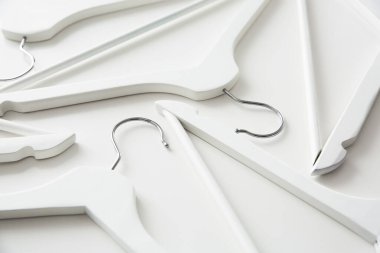 Beyaz ahşap elbise askıları ve beyaz arka planda askılar. Satış ve alışveriş konsepti.