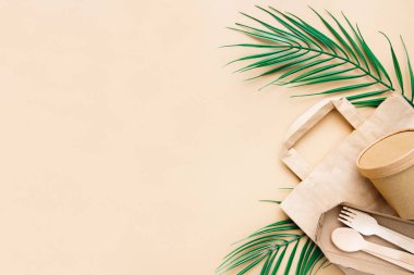 Sıfır atık, çevre dostu, tek kullanımlık, karton, bej arka planda kağıt kaplar. Yukarıdan bak. Eko el işi kağıt sofra takımı.