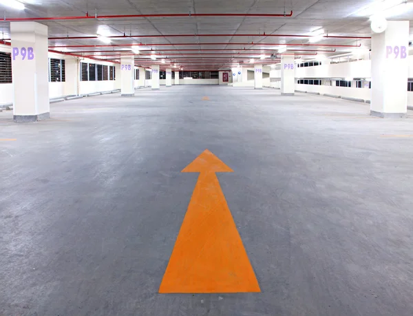 Empty parking garage with yellow arrow — Stock Photo, Image