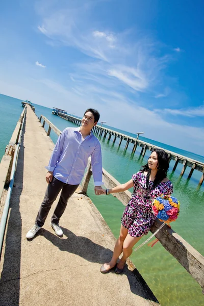 Unga bruden och brudgummen på fiskare pier med vacker himmel — Stockfoto