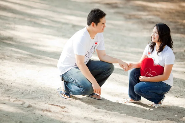 Young boy holding his pretty girlfriend hand on the beach — Stock Photo, Image