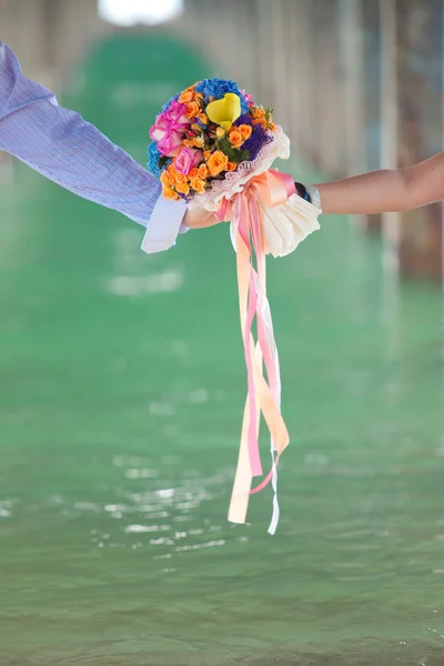 two hand holding beautiful flower bouquet, vertical