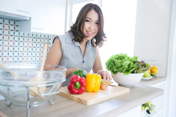 Mujer de pie en el mostrador de la cocina — Foto de Stock