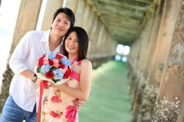 Portret van aantrekkelijke paren onder de pier op het strand — Stockfoto