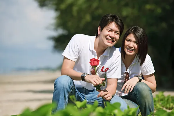 Boy giving beautiful rose to his pretty girlfriend — Stock Photo, Image