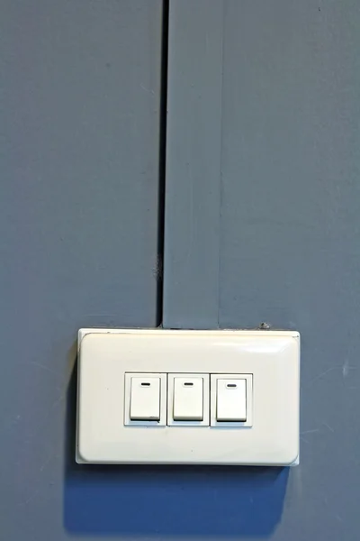 Tripple interrupteur lumineux sur le mur gris — Photo