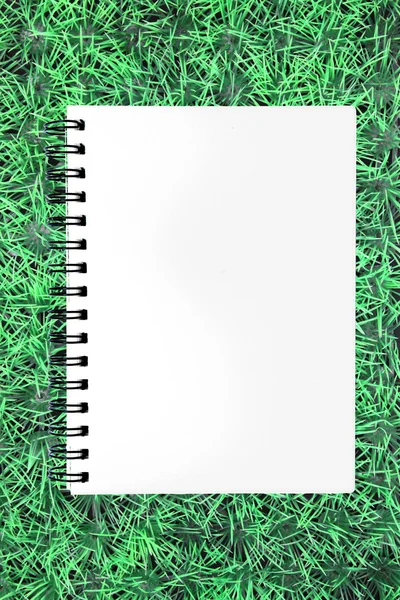 Blank ring binding paper on green grass — Stock Photo, Image