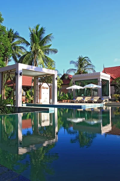 Tropikal Bahçe ve spa bölümü ile plaj sandalyesini havuza yansıması — Stok fotoğraf