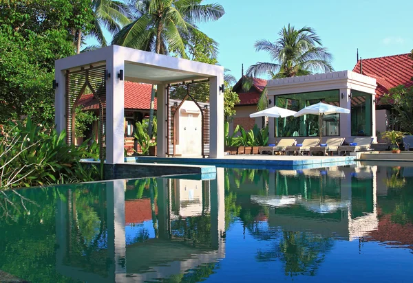 Reflexão da Piscina no Jardim Tropical e Spa Seção com cadeira de praia — Fotografia de Stock