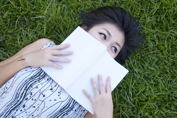 Young woman reading a book in the field — Stock Photo, Image