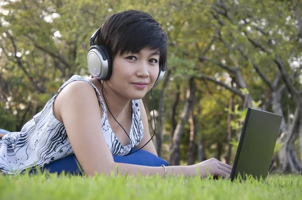 아름 다운 아시아 여자는 공원에서 듣는 음악 — 스톡 사진