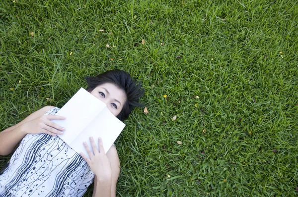 Young woman reading a book in the field — Stock Photo, Image