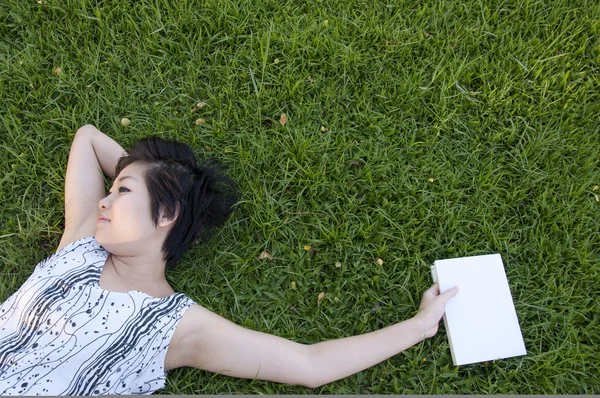 Jeune femme lisant un livre sur le terrain — Photo