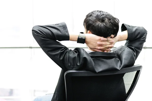 Vue arrière de Businessman relaxant dans une chaise noire — Photo