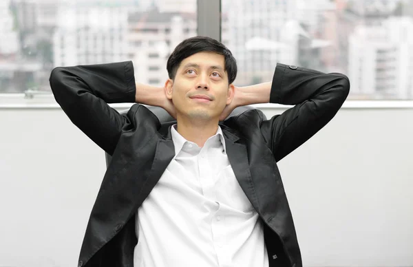 Relaxed businessman sitting in office — Stock Photo, Image