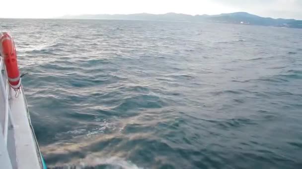 Un barco de mar está caminando sobre las olas en un día nublado y salpicaduras están volando. — Vídeos de Stock